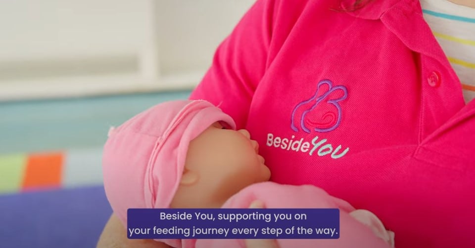 Peer supporter demonstrating breastfeeding with a doll