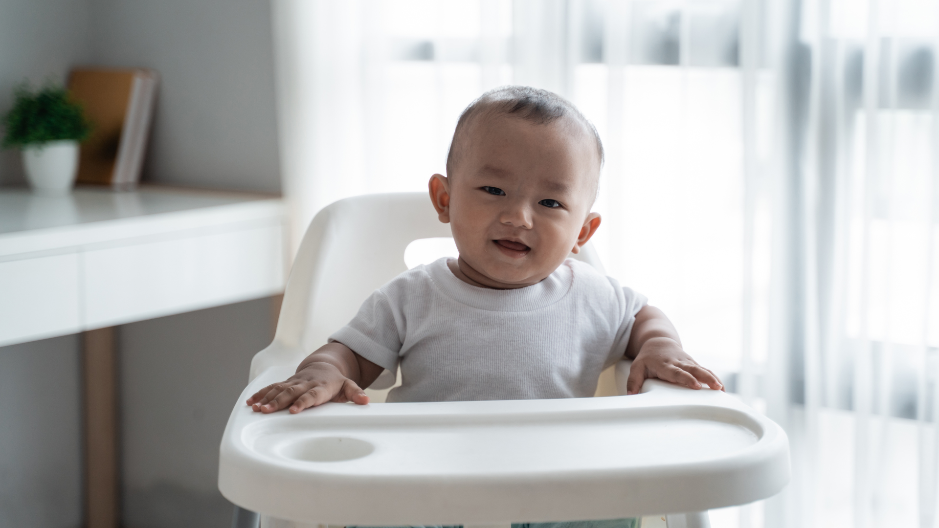 Smiling baby sitting in highchair